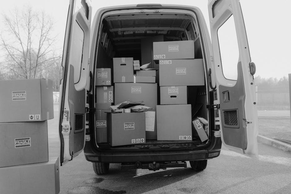 Home Open delivery van loaded with various boxes labeled as fragile, ready for shipment.